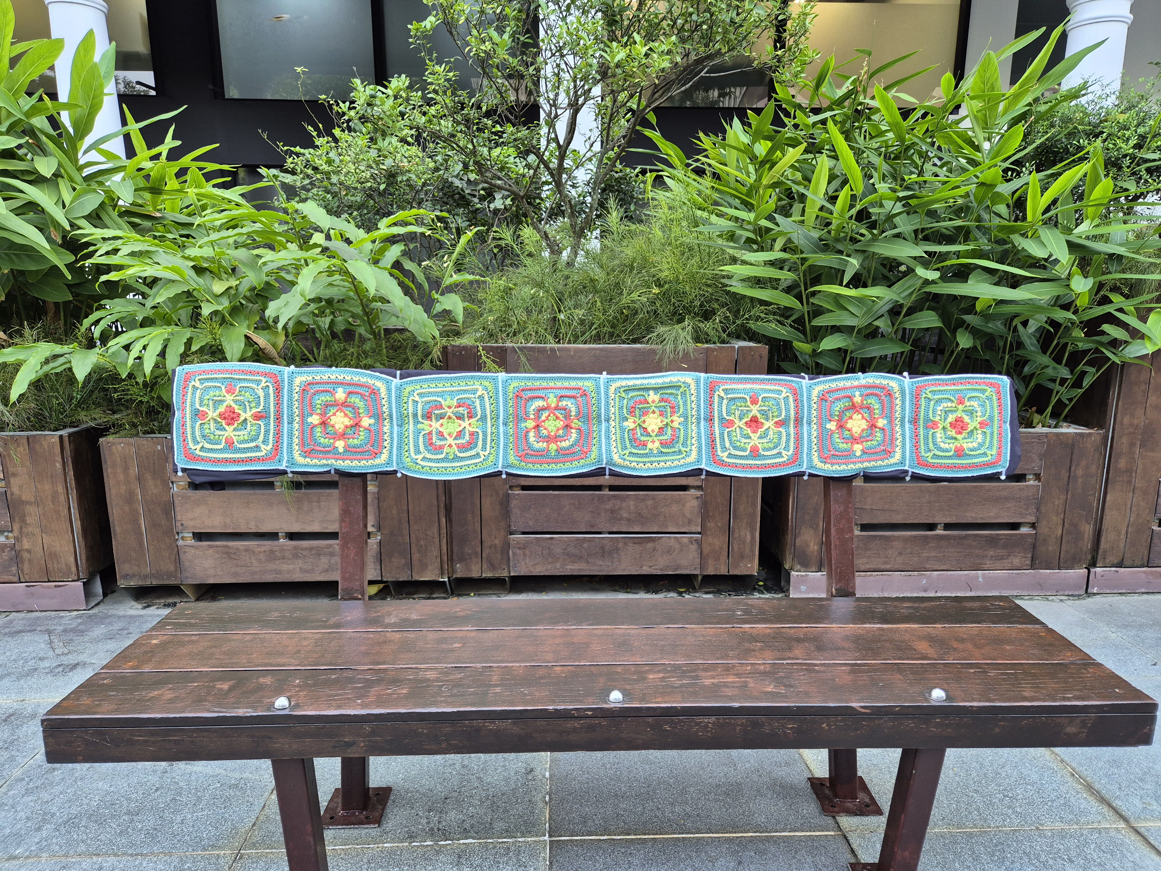 Crocheted Peranakan tile panel on a bench at Armenian Street for Singapore Art Week.